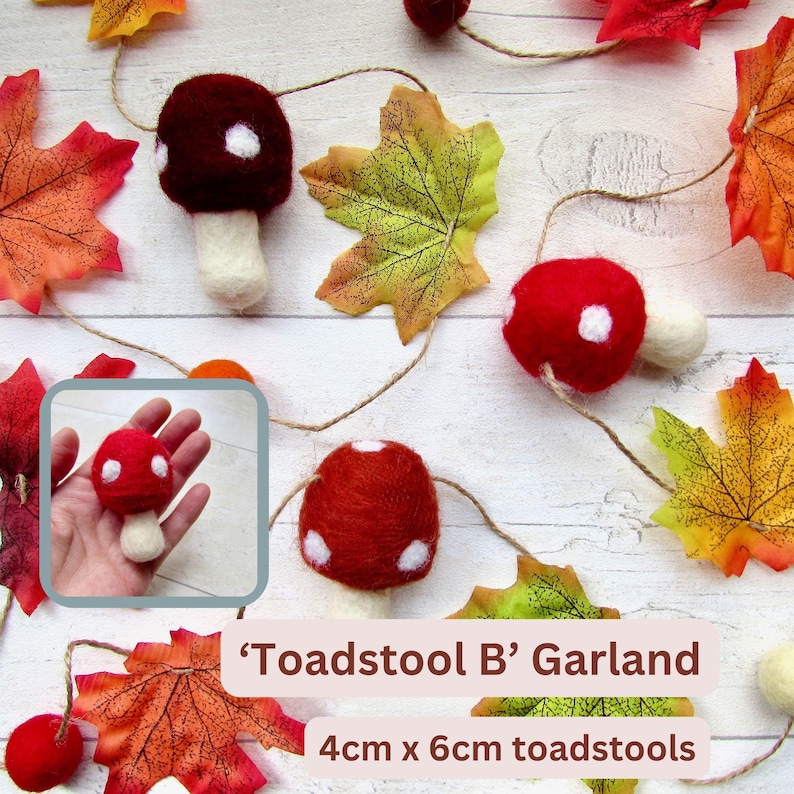 May include: A garland featuring felted toadstools with red and dark red caps with white spots and cream-colored stems, interspersed with artificial autumn leaves on a string. The toadstools measure 4cm x 6cm. Text reads 'Toadstool B' Garland.