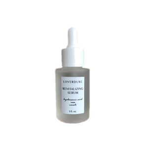 May include: A clear glass bottle with a white dropper top. The bottle is labeled "LOVERDURE REVITALIZING SERUM hyaluronic acid rose neroli 1 fl. oz."