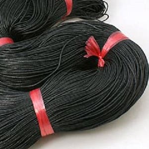 Peut inclure: Deux bobines de cordon ciré noir, chacune enveloppée de plastique rouge.