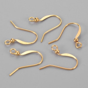 Könnte beinhalten: Vier goldfarbene Ohrhaken mit einer kleinen Kugel an der Spitze jedes Hakens.