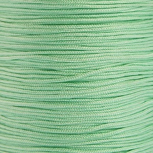 May include: A spool of light green cord, perfect for crafting projects.