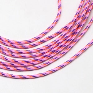 May include: A close-up of pink, orange and purple striped cord. The cord is made of a woven material and is soft to the touch.