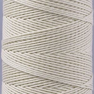 Op de afbeelding: Een spoel met natuurlijke witte katoenen touw. Het touw is strak gewikkeld en heeft een gladde, gelijkmatige textuur.