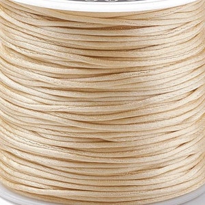May include: A spool of cream-colored waxed cord, perfect for jewelry making, macrame, or crafts.