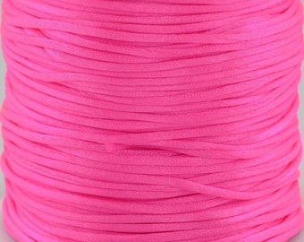 May include: A spool of bright pink waxed cotton cord. The cord is wound tightly around the spool, creating a smooth, even surface.