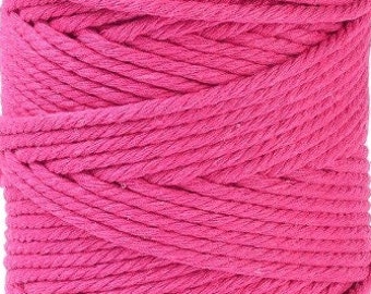 Könnte beinhalten: Eine Spule mit leuchtend pinkfarbenem Baumwollseil. Das Seil ist dick und gedreht und perfekt für Bastelprojekte.