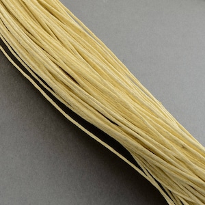 Könnte beinhalten: Ein Bündel natürlicher cremefarbener Schnur, perfekt für Bastelarbeiten und DIY-Projekte.