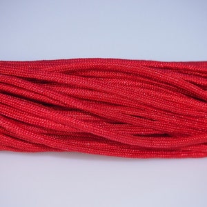 Könnte beinhalten: Nahaufnahme eines Stapels leuchtend roten Paracord.