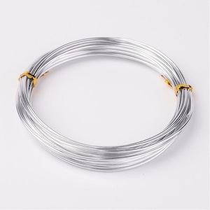 Könnte beinhalten: Eine Rolle silberfarbenes Draht mit goldfarbenen Enden. Der Draht ist aufgerollt und bereit für Bastelprojekte.