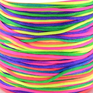 May include: A spool of colourful rainbow cord, with shades of pink, green, yellow, and purple.