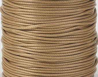 May include: A spool of brown waxed cotton cord. The cord is wound tightly around the spool and is ready to be used for crafting projects.