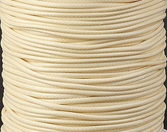 May include: A spool of off-white waxed cotton cord. The cord is tightly wound and has a smooth, polished finish.