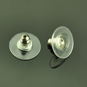 Könnte beinhalten: Zwei transparente Ohrstecker aus Kunststoff mit einem silbernen Metallstift. Die Ränder sind rund und haben eine erhabene Mitte.