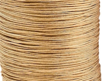 May include: A spool of tan colored cord. The cord is tightly wound and appears to be made of a synthetic material.