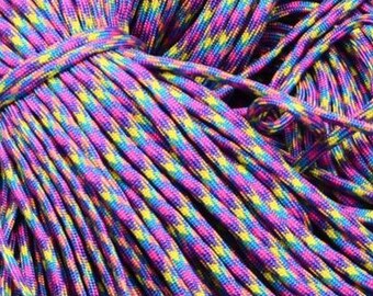 Puede incluir: Primer plano de una cuerda de paracord multicolor. La cuerda está hecha de un material grueso y duradero y está disponible en una variedad de colores. La cuerda es perfecta para manualidades, acampar y otras actividades al aire libre.