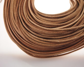 May include: A close-up of a coil of brown leather cord. The cord is smooth and supple, and it is perfect for crafting projects.