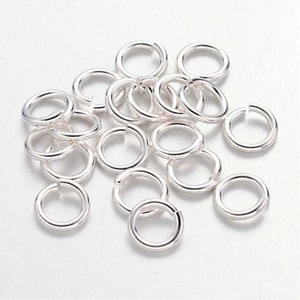 Op de afbeelding: Een stapel zilveren springringen, een soort sieraadbevestiging die wordt gebruikt om kettingen, koorden en andere sieraadcomponenten te verbinden.