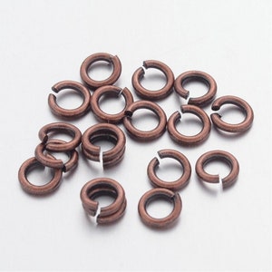 May include: A pile of copper jump rings, a type of jewelry finding used for connecting chains, cords, and other jewelry components.