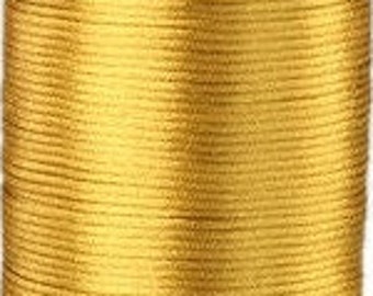 May include: A spool of gold-colored cord or thread. The cord is wound tightly around the spool.