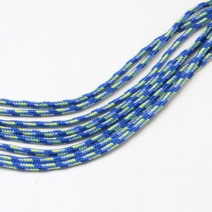 Puede incluir: Primer plano de un paracord azul y verde, un tipo de cuerda que se utiliza a menudo para manualidades y actividades al aire libre.