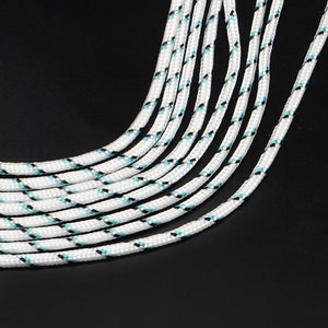 May include: A close-up of a bundle of white rope with black and blue stripes. The rope is arranged in a fan shape.