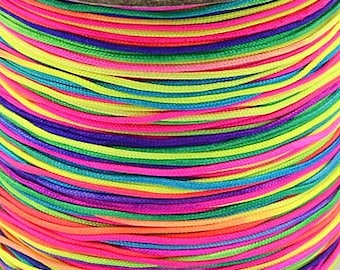 Puede incluir: Una bobina de hilo de bordar arcoíris de colores. El hilo está enrollado firmemente alrededor de la bobina y está hecho de una variedad de colores brillantes, incluyendo rojo, naranja, amarillo, verde, azul, índigo y violeta.