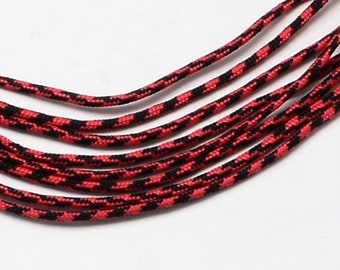 May include: A close-up of red and black paracord, a type of strong nylon rope often used for crafting and outdoor activities.