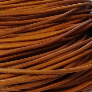 Könnte beinhalten: Nahaufnahme einer Rolle brauner Lederschnur. Die Schnur ist eng gewickelt und weist eine glatte, leicht glänzende Oberfläche auf. Die Farbe ist ein warmes, mittleres Braun mit Farbtonvariationen. Geeignet für Schmuckherstellung und Bastelarbeiten.