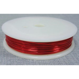 May include: A spool of red enameled copper wire. The wire is wound around a white plastic spool.
