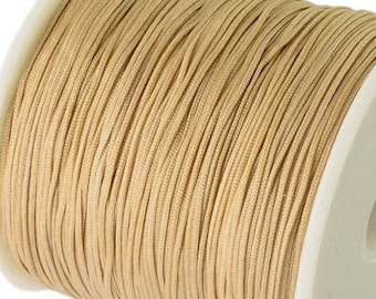 May include: A spool of beige waxed cord, perfect for crafting and jewelry making.