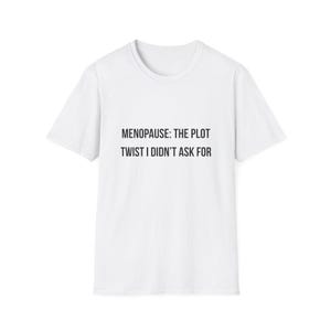 Puede incluir: Camiseta blanca con el texto negro "MENOPAUSE: THE PLOT TWIST I DIDN'T ASK FOR". La camiseta tiene cuello redondo y mangas cortas, ideal para uso diario. El texto está centrado.