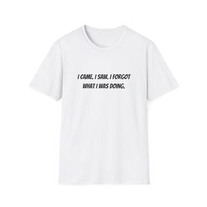 May include: White t-shirt with the phrase "I CAME, I SAW, I FORGOT WHAT I WAS DOING" printed in black, centered on the front. The shirt has a crew neck and short sleeves. The fabric appears to be a soft cotton blend.