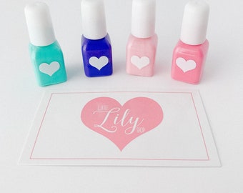 May include: Four small bottles of nail polish in turquoise, blue, pink, and light pink. Each bottle has a white heart sticker on the front. The bottles are arranged in a row on a white surface. A pink heart with the text "Little Lily Shop" is below the bottles.