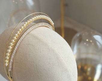 May include: A gold headband with a row of pearls and a row of clear rhinestones.