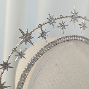 Puede incluir: Diadema plateada con una fila de brillantes strass en forma de estrella. La diadema est&aacute; dise&ntilde;ada para sentarse en la parte superior de la cabeza y tiene un aspecto delicado y femenino.
