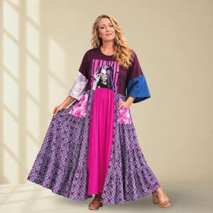 May include: A floor-length dress featuring a dark purple bodice with a graphic print of a person wearing pink sunglasses, a bright pink central panel, and a tiered skirt with a blue and purple floral pattern. It has one tie-dye and one blue sleeve.