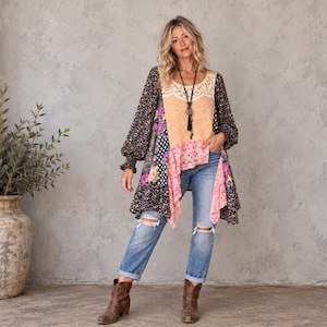May include: A long-sleeved tunic featuring a patchwork design with floral, polka dot, and lace patterns in shades of peach, black, and pink. The garment is paired with light blue distressed denim jeans and brown leather ankle boots.