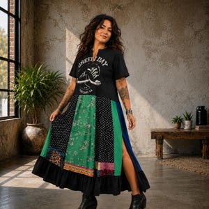Peut inclure: Une robe t-shirt noire à manches courtes avec un motif de deux baskets et le texte Green Day Oakland, CA. La jupe présente un design en patchwork avec des panneaux verts, noirs et à motifs floraux, une fente latérale et un ourlet à volants.