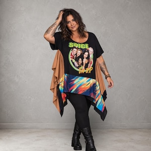May include: A black short-sleeve tunic featuring a circular graphic of the Spice Girls with the text SPICE UP YOUR LIFE. The garment has tan side panels with vertical ruffles and a multicolored abstract print along the bottom hemline.