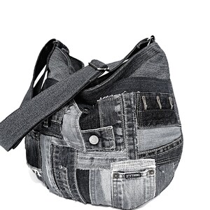 Puede incluir: Un bolso tote de patchwork de mezclilla negra con una correa larga ajustable. El bolso tiene una variedad de parches de mezclilla cosidos juntos, incluyendo algunos con bolsillos y una etiqueta que dice "PYTHON".
