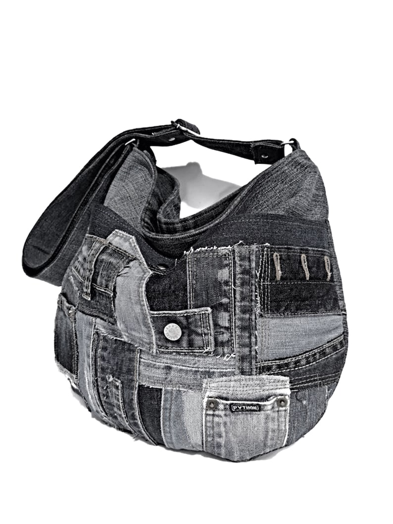 Puede incluir: Un bolso tote de patchwork de mezclilla negra con una correa de cuero negro. El bolso est&aacute; hecho de diferentes piezas de mezclilla, algunas con costuras visibles y bordes deshilachados. El bolso tiene un peque&ntilde;o bolsillo en la parte delantera con la palabra "PYTHON" impresa en &eacute;l.