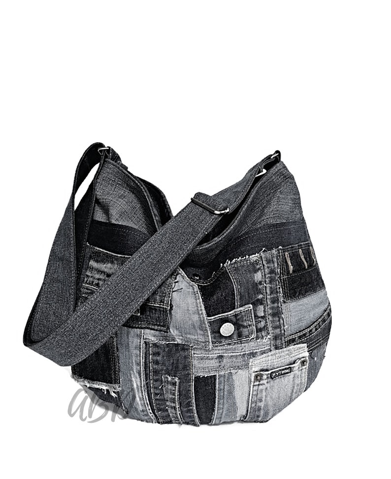 Puede incluir: Un bolso tote de mezclilla negro hecho de mezclilla reciclada con un dise&ntilde;o de patchwork. El bolso tiene una correa larga y un cierre de cremallera.