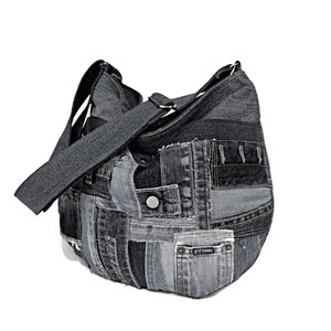 Puede incluir: Un bolso tote de mezclilla negro hecho de mezclilla reciclada con un dise&ntilde;o de patchwork. El bolso tiene una correa larga y un bolsillo peque&ntilde;o en la parte delantera.