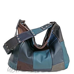 Peut inclure: Un sac hobo en cuir patchwork dans les tons marron, bleu et noir. Le sac est doté d'une large bandoulière avec des rivets argentés et d'une fermeture éclair. Le design du sac est un mélange de formes géométriques.