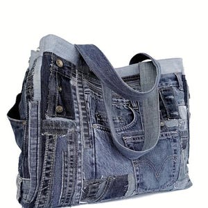 Może przedstawiać: Duża niebieska torba typu tote wykonana z recyklingowanych dżinsów. Torba ma patchworkowy wzór z wieloma kieszeniami i długim paskiem.