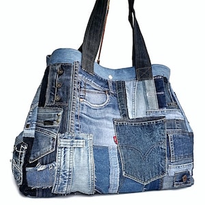 May include: A large tote bag made from recycled denim. The bag has a patchwork design with different shades of blue denim and a red Levi's patch. The bag has two black denim straps.