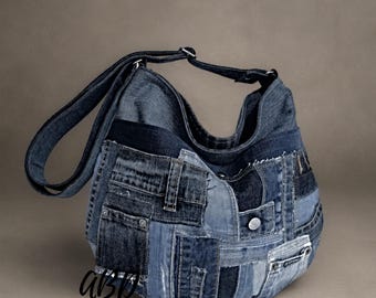 May include: A hobo-style shoulder bag constructed from various shades of blue denim fabric patches. The bag features visible seams, multiple pockets, metal rivets, and a single adjustable denim strap. The letters ABD are printed in black on the front.