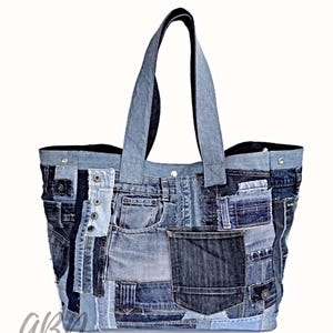 Op de afbeelding: Een grote blauwe denim tote bag gemaakt van gerecyclede jeans. De tas heeft meerdere zakken en is patchwork-stijl.