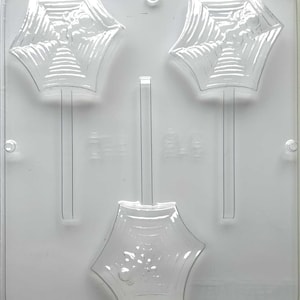 May include: A clear, plastic candy mold featuring three umbrella-shaped cavities. The mold is designed for making lollipops or chocolates with a seasonal or party theme. The umbrella tops have detailed ribbing.