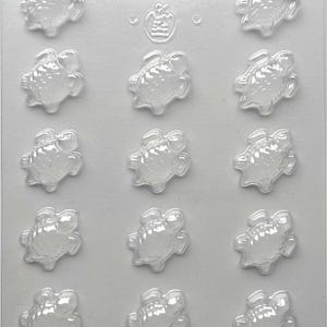 May include: Clear plastic mold with twelve turtle-shaped cavities. The mold has the number "90-12903" printed at the top. The cavities are arranged in three rows of four, each depicting a turtle with detailed shell and flippers.